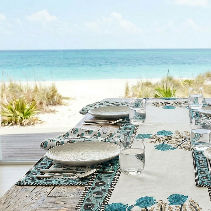 Dining table set with floral tablecloth and place settings by the beach